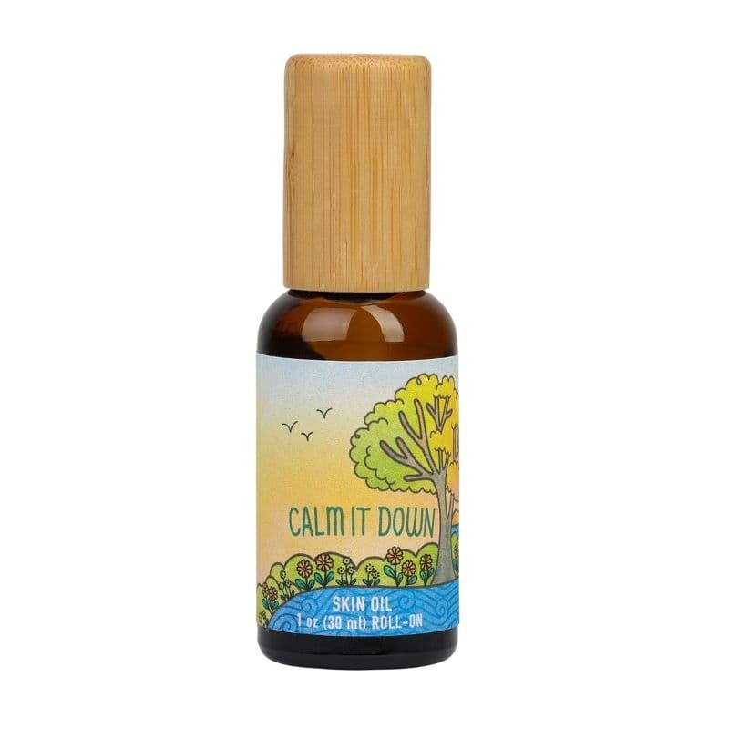 Amber glass Calm It Down skin oil roll-on with a bamboo cap, on white.