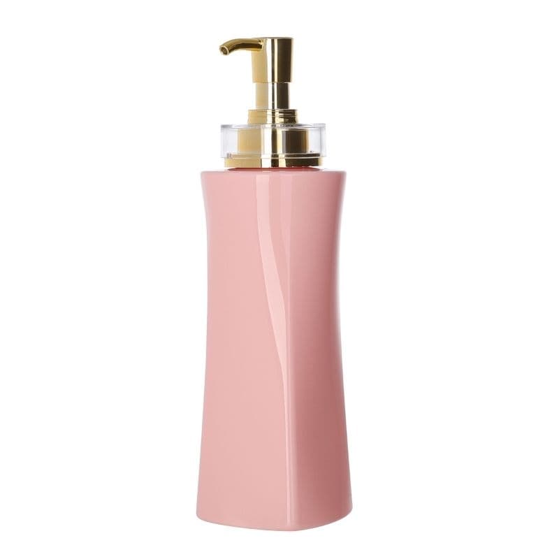 Glossy blush-pink lotion pump bottle with a gold dispenser, on white.