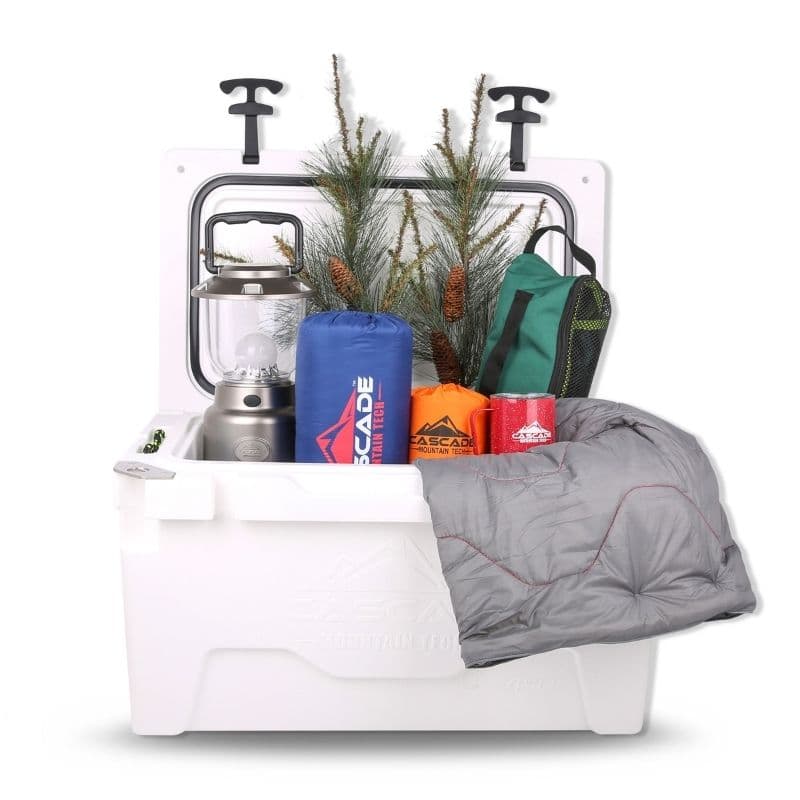 Open white Cascade Mountain Tech cooler packed with lantern, stuff sacks, mug, and blanket.